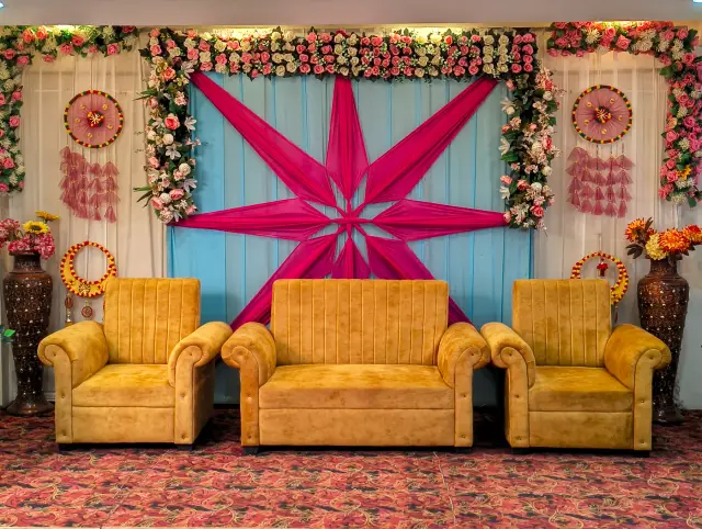 Gold sofa seating in front of a pink star-shaped fabric backdrop inside Jagan Palace