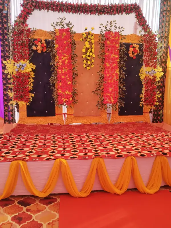 Wedding stage with marigold and red floral backdrop