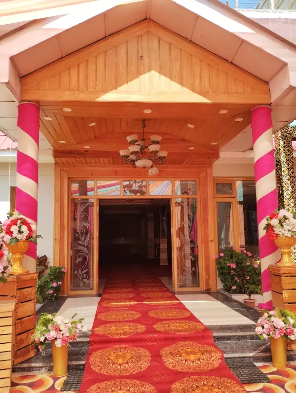 Decorated main entrance with pink pillars and floral pots