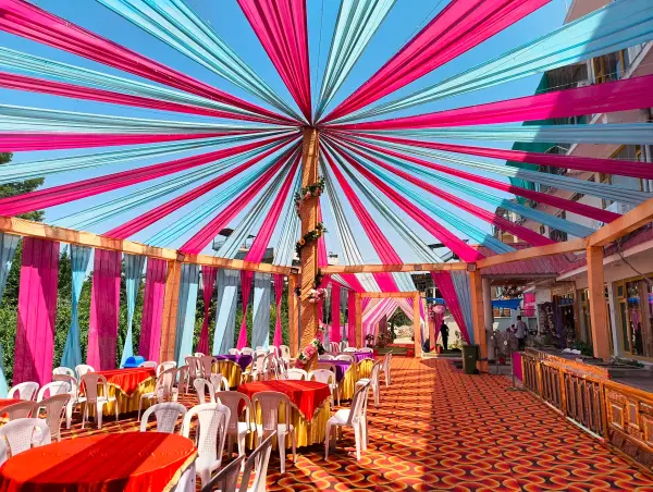 Rooftop terrace canopy with pink and teal drapes over dining tables